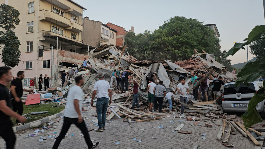 People rush to a collapsed building to search for survivors after an earthquake in Sindirgi in the western Balikesir province, Turkey, August 10, 2025. Ihlas News Agency (IHA) via REUTERS