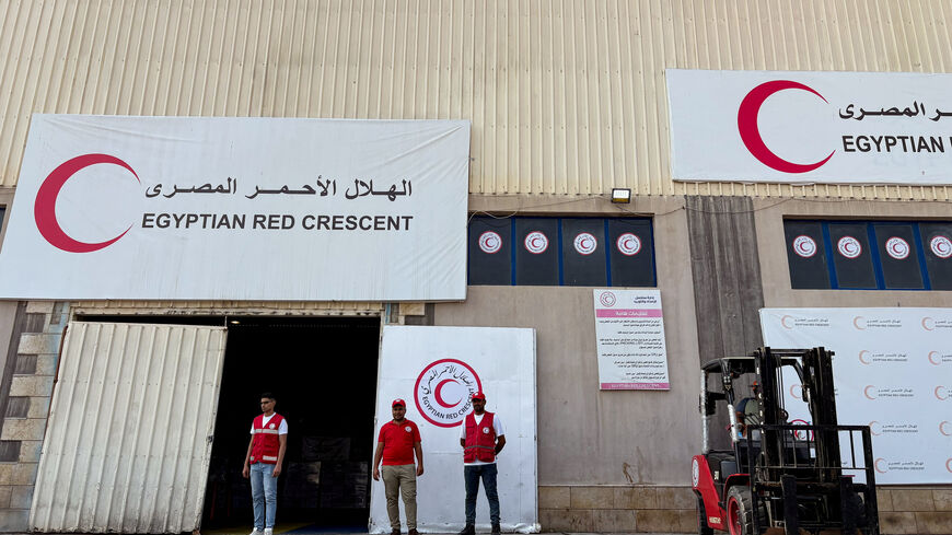 People stand in front of a warehouse for aid deliveries, waiting to be delivered to Gaza, at a logistics site run by the Egyptian Red Crescent, outside Arish, Egypt, August 11, 2025. REUTERS/Alexander Dziadosz/File Photo