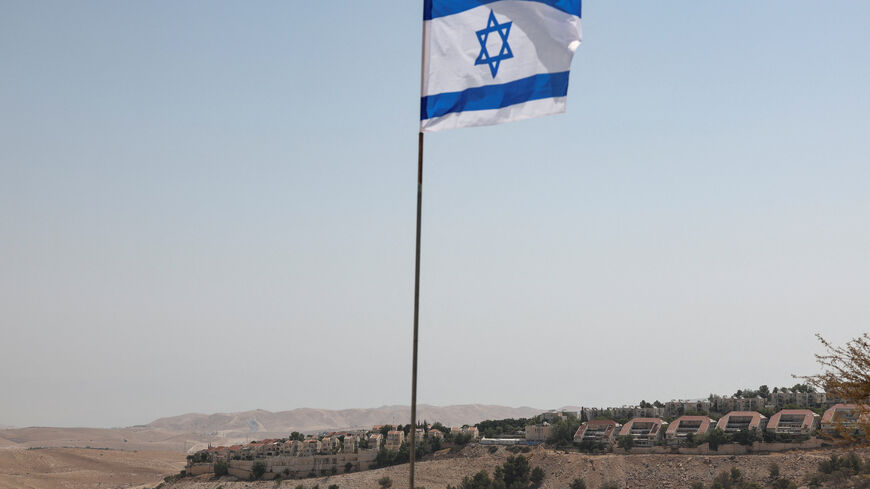 FILE PHOTO: An Israeli flag flutters, as part of the Israeli settlement of Maale Adumim is visible in the background, in the Israeli-occupied West Bank, August 14, 2025. REUTERS/Ronen Zvulun/File Photo