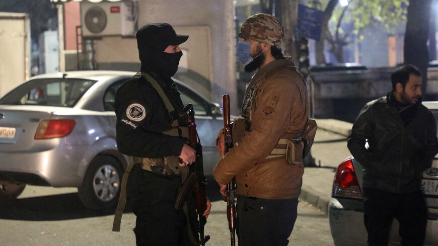 FILE PHOTO: Members of the former rebel group Hayat Tahrir al-Sham stand guard on a street to monitor security and prevent crime in their districts after the ouster of Syria's Bashar al-Assad, in Damascus, Syria, December 31, 2024. REUTERS/Khalil Ashawi/File Photo