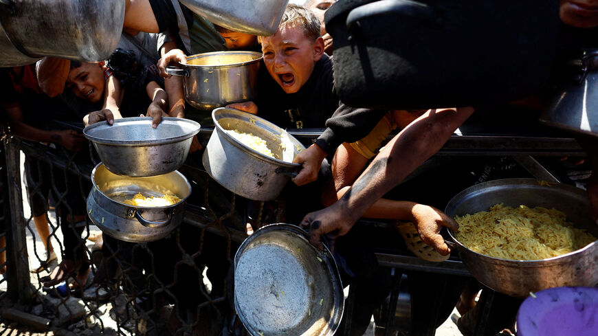 Palestinians wait to receive food from a charity kitchen after the global hunger monitor, Integrated Food Security Phase Classification (IPC), said that Gaza City and surrounding areas are officially suffering from famine that will likely spread, in Gaza City, August 28, 2025. REUTERS/Mahmoud Issa