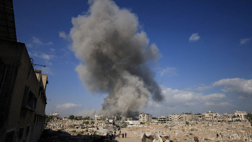 FILE PHOTO: Palestinians gather near a cemetery as smoke rises following an explosion during an Israeli operation in Gaza City, August 28, 2025. REUTERS/Dawoud Abu Alkas/File Photo