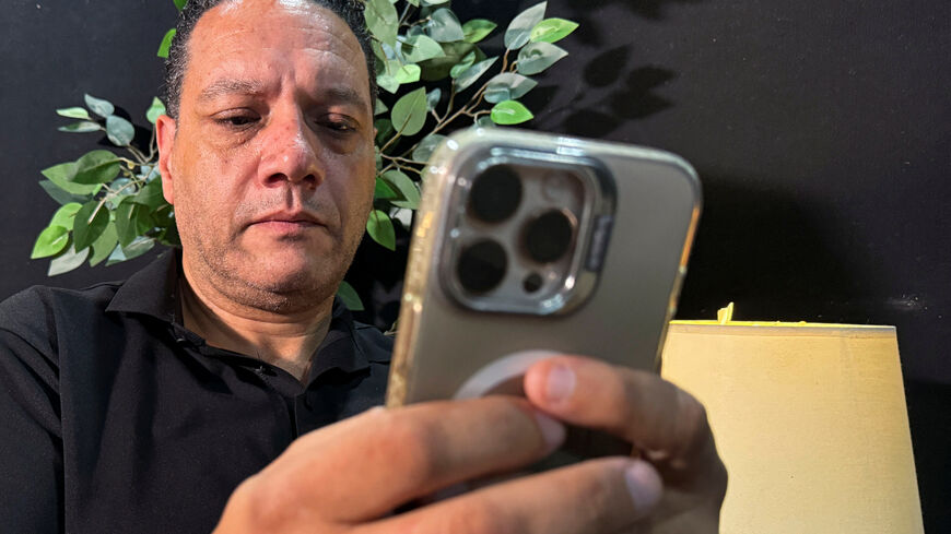 Ramy Abdel Aziz, a social media advisor uses his mobile during an interview with Reuters on a wave of cases prompting Egypt to consider tighter regulations on social media platforms, at his office in Cairo, Egypt August 19, 2025. REUTERS/Sayed Sheashaa