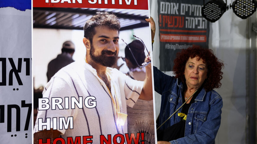 FILE PHOTO: A woman holds a poster with an image of Idan Shtivi, in Tel Aviv, Israel, as hostages are released by the Palestinian militant group Hamas, amid a hostages-prisoners swap deal between Hamas and Israel, November 26, 2023. REUTERS/Athit Perawongmetha/File photo