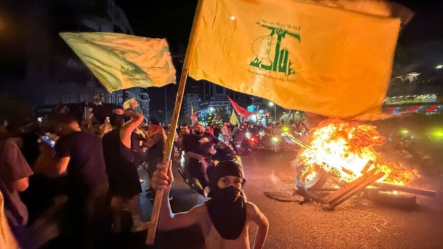 Supporters of Lebanon's Hezbollah militant group block the streets in Beirut with burning tires as they rally in cars and motorbikes to protest the government's endorsement of a plan to disarm it