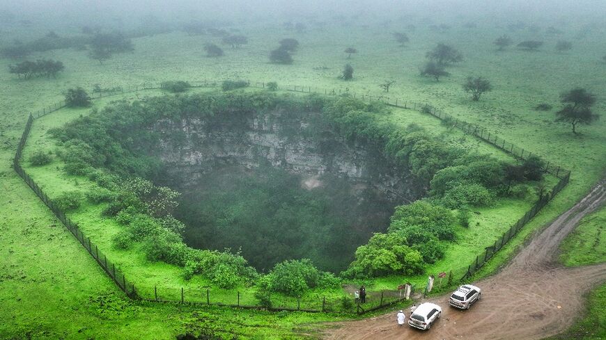 The sheer drop of the Sheeheet pit, one of four that dot Oman's Dhofar region, is ringed with slippery mud, prompting the authorities to put up a fence and warning signs.