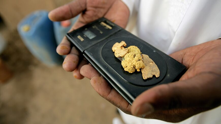A Sudanese merchant weighs pure gold on an electronic scale in the village of al-Shirik in northern Sudan on Aug. 8, 2010.