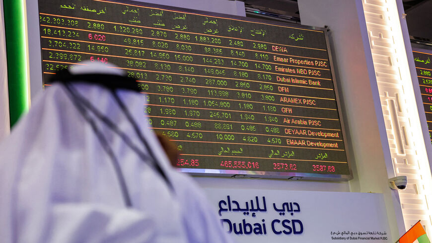 A man watches stock movements on a display at the Dubai Financial Market stock exchange, United Arab Emirates, April 12, 2022.