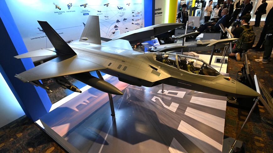 Participants look at a miniature of KF-21 fighter jet (front) on display at the Responsible AI in the Military Domain (REAIM) summit in Seoul on Sept. 10, 2024. 