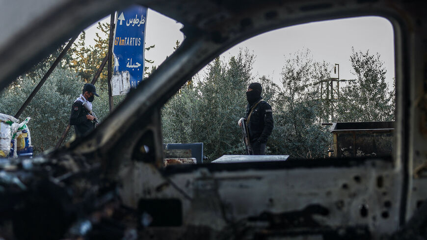 Security forces loyal to the interim Syrian government stand guard at a checkpoint previously held by supporters of deposed president Bashar al-Assad, in the town of Hmeimim, in the coastal province of Latakia, on March 11, 2025.  