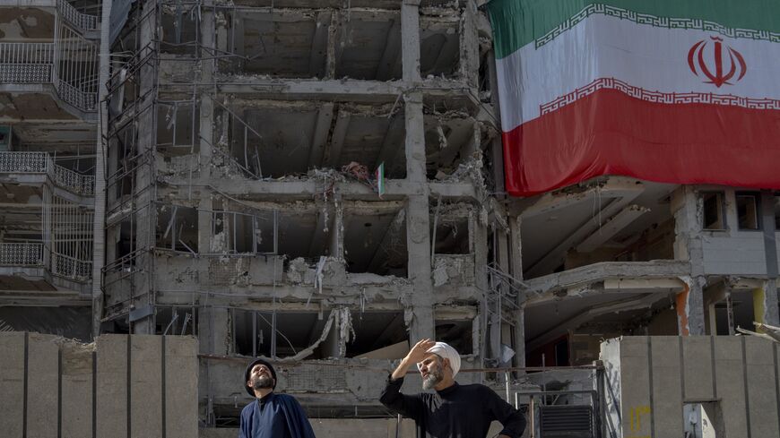  Two men look at houses destroyed in Israeli attacks, July 12, 2025, Tehran.
