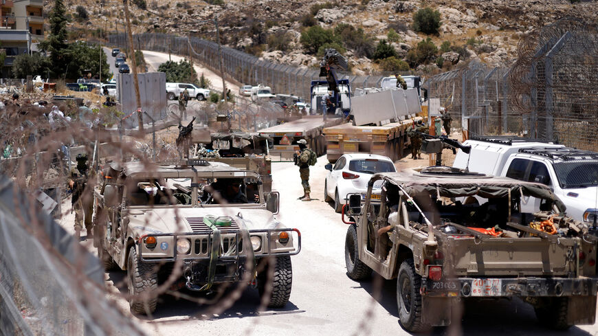 Israel military vehicles drive along the border fence into Israel, near the town of Majdal Shams, in the Israeli-annexed Golan Heights, July 17, 2025.
