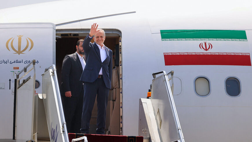 Iran's President Masoud Pezeshkian waves as he boards a plane at Tehran's Mehrabad Airport on Aug. 18, 2025, ahead of his trip to Armenia. 