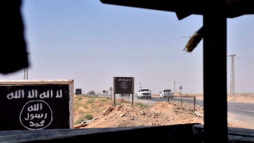 Billboards show the logo of the Islamic State (IS) group near the village of al-Maleha, in the northern countryside of Deir Ezzor, where Syrian pro-government forces are holding a position on September 9, 2017, during the ongoing battle against IS jihadists. Syrian troops broke the Islamic State group's siege of the eastern Deir Ezzor military airport, dealing a new blow to the jihadists who were facing a new offensive from US-backed fighters elsewhere in the province. (Photo by George OURFALIAN / AFP) (Pho