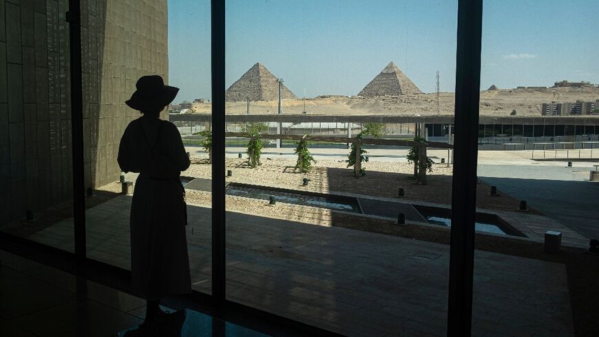 A visitor looks out towards the Giza pyramid complex as she tours the Grand Egyptian Museum in Giza on the southwestern outskirts of the capital Cairo on May 5, 2025