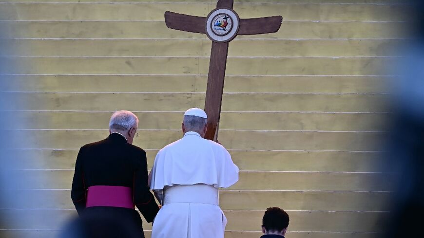 The pope took to the stage carrying a large wood cross