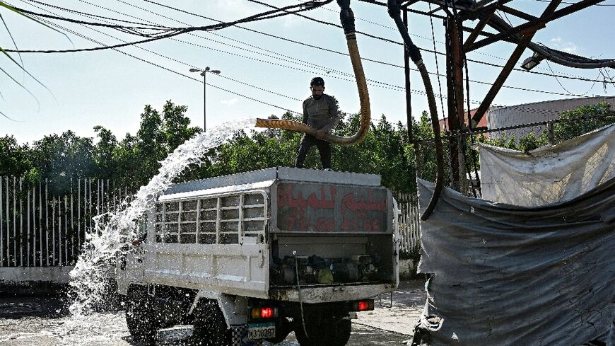 A man fills a delivery truck with water at a distribution facility in Beirut, where record-low rainfall is exacerbating pressure on the state water supply