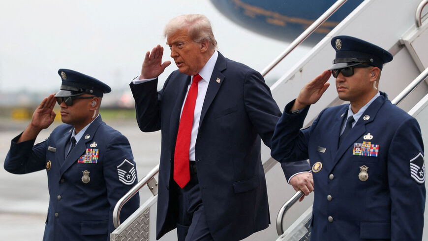 U.S. President Donald Trump salutes as he disembarks Air Force One upon his arrival at La Guardia Airport in New York for the U.S. Open men's tennis final, U.S., September 7, 2025. REUTERS/Evelyn Hockstein