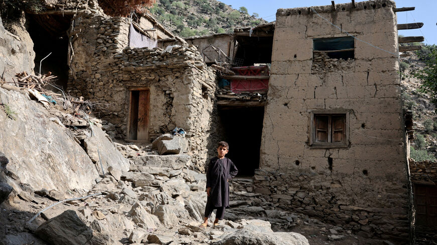 FILE PHOTO: A boy stands in front of houses damaged by a deadly earthquake that struck Afghanistan's Kunar and Nangarhar provinces, at Masud village in Nurgal district, Kunar province, Afghanistan, September 4, 2025. REUTERS/Sayed Hassib/File Photo