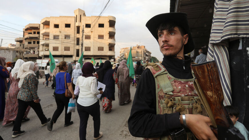 FILE PHOTO: A member of the Kurdish-led Syrian Democratic Forces (SDF) stands guard as Syrian Kurds attend a protest in solidarity with people in Sweida, after scores of people have been killed this week in violence in and around the predominantly Druze city of Sweida, pitting fighters from the Druze minority against government security forces and members of Bedouin tribes, in Qamishli, Syria July 17, 2025. REUTERS/Orhan Qereman/File Photo