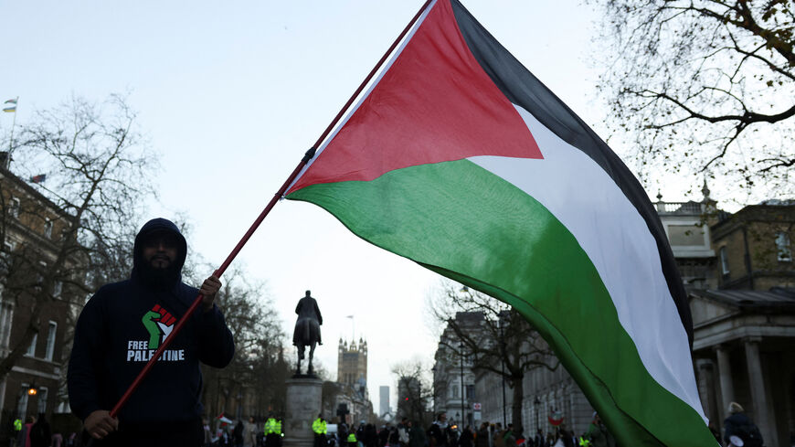 FILE PHOTO: A person holds a Palestinian flag during a protest in solidarity with Palestinians in Gaza, amid the ongoing conflict between Israel and the Palestinian Islamist group Hamas, in London, Britain, December 9, 2023. REUTERS/Hollie Adams/File Photo