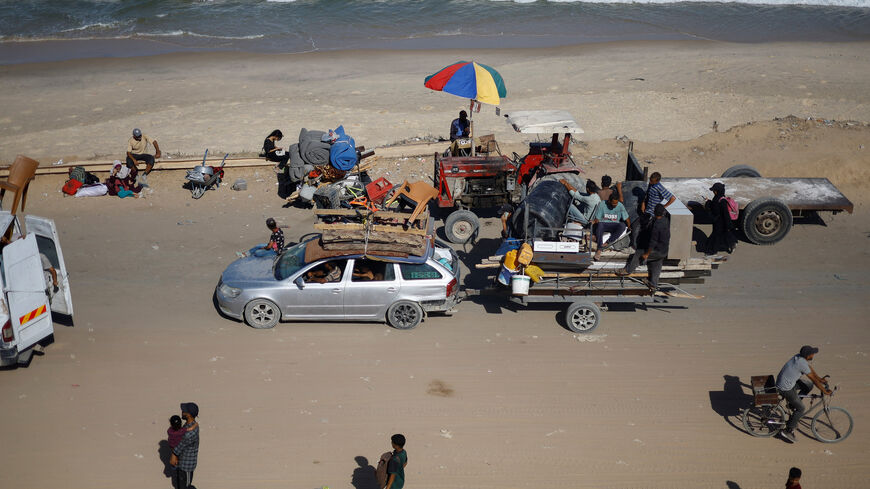 Displaced Palestinians, fleeing northern Gaza due to an Israeli military operation, move southward, hauling personal belongings along the shore, after Israeli forces ordered residents of Gaza City to evacuate to the south, in the central Gaza Strip, September 21, 2025. REUTERS/Mahmoud Issa