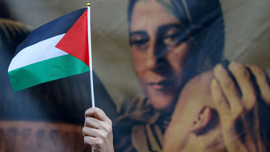 An attendee holds a Palestinian flag during a ceremony at the headquarters of the Palestinian mission to the United Kingdom, after the British government announced on Sunday the country's formal recognition of a Palestinian state, in London, Britain, September 22, 2025. REUTERS/Toby Melville