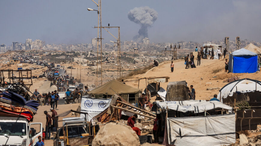 Smoke rises from an Israeli strike, as displaced Palestinians, fleeing northern Gaza due to an Israeli military operation, move southward after Israeli forces ordered residents of Gaza City to evacuate to the south, in the central Gaza Strip September 22, 2025. REUTERS/Dawoud Abu Alkas
