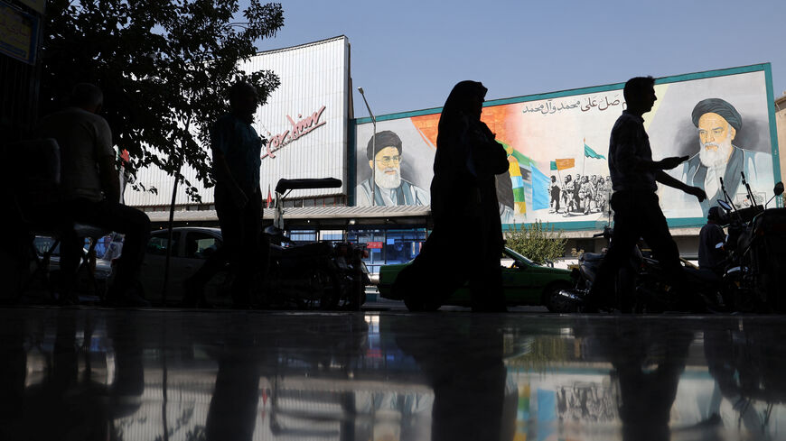 FILE PHOTO: People walk past a mural depicting the late leader of the Islamic Revolution Ayatollah Ruhollah Khomeini and Iran's Supreme Leader Ayatollah Ali Khamenei on a building in a street in Tehran, Iran, October 7, 2024. Majid Asgaripour/WANA (West Asia News Agency) via REUTERS/ File Photo
