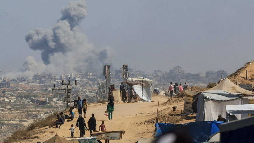 FILE PHOTO: Smoke rises from an Israeli strike, as displaced Palestinians, fleeing northern Gaza due to an Israeli military operation, move southward after Israeli forces ordered residents of Gaza City to evacuate to the south, in the central Gaza Strip September 24, 2025. REUTERS/Dawoud Abu Alkas/ File Photo