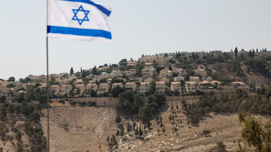 An Israeli flag flutters, as part of the Israeli settlement of Maale Adumim is visible in the background, in the Israeli-occupied West Bank, August 14, 2025. REUTERS/Ronen Zvulun/File Photo