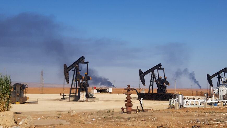 This picture shows pumpjacks in an oil field and smoke plumes rising in the background, following reported Turkish drone strikes near the town of al-Qahtaniyah in Syria's northeastern Hasakah province, close to the border with Turkey, on Nov. 23, 2022.