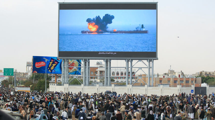 Images of a fireball exploding on a cargo ship are shown on a giant screen during a protest called for by Yemen's rebel Houthi movement in Sanaa on March 17, 2025. 