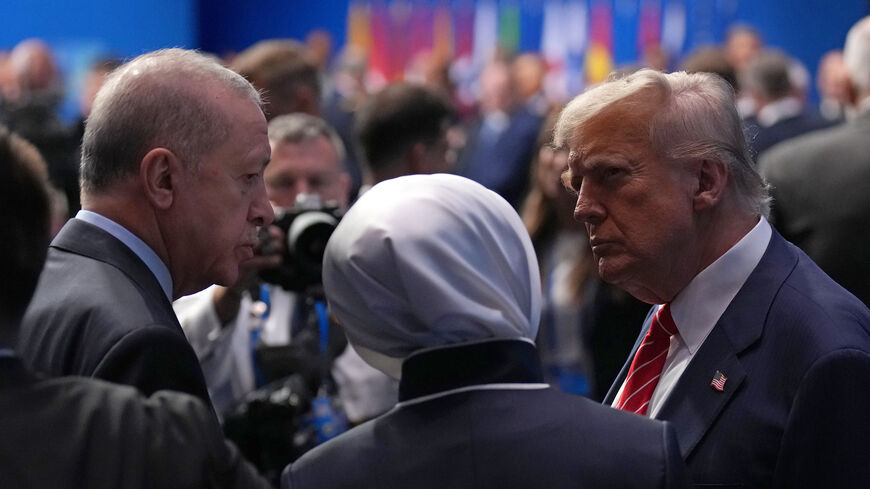 President Donald Trump (R) speaks with President of the Republic of Turkey, Recep Tayyip Erdogan (L), as they arrive for the North Atlantic Council Plenary Session on the second day of the 2025 NATO Summit on June 25, 2025 in The Hague, Netherlands. 