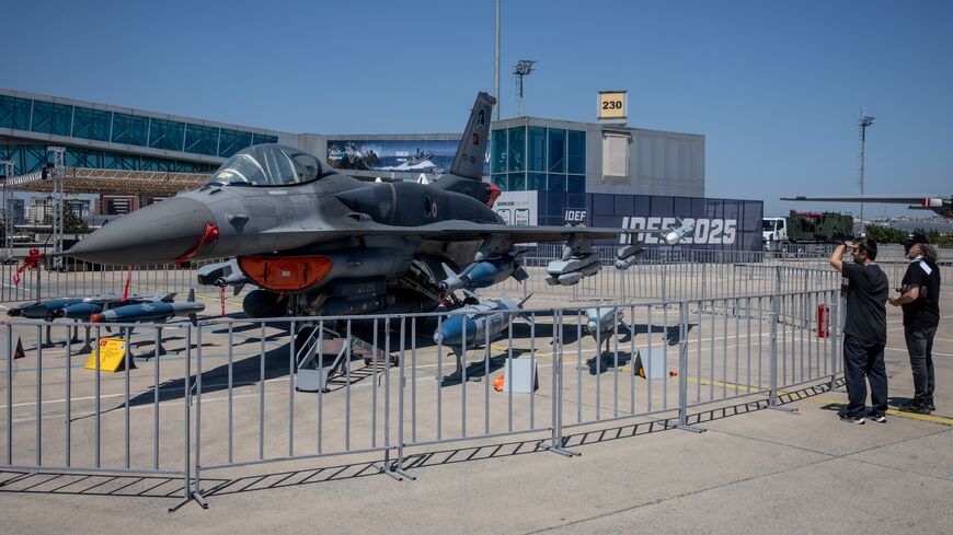 People look at a Turkish fighter jet on display at Turkey's 17th International Defense Industry Fair (IDEF) in Istanbul on July 25, 2025, in Istanbul, Turkey. 