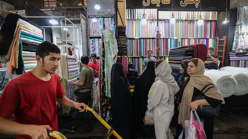 Iranians walk past shops in the Grand Bazaar in Tehran on Aug. 13, 2025.