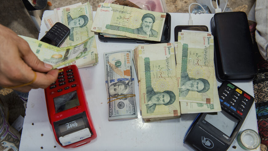 Stacks of Iranian rials and US dollars sit counted on a table in an unofficial currency exchange shop, Tehran, Iran, Aug. 6, 2025.