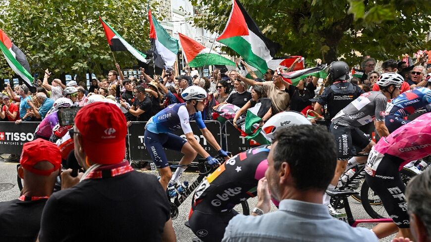 Israel Premier-Tech's Italian rider Marco Frigo passes pro-Palestinian demonstrators at the start of the 12th stage of the Vuelta a Espana, in Laredo