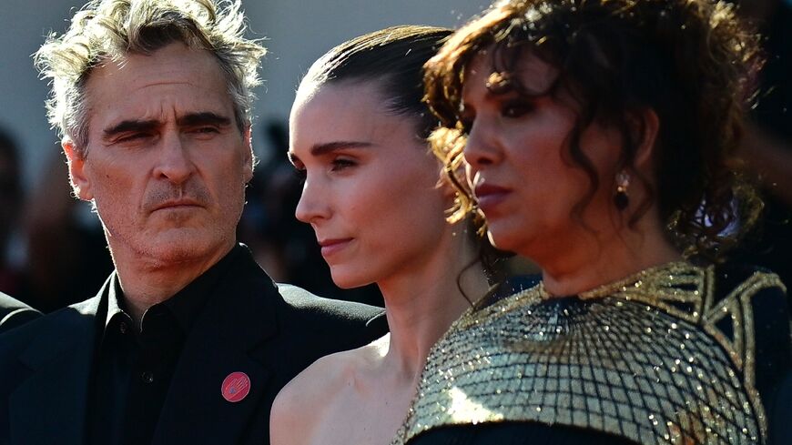 The powerful movie, by French-Tunisian director Kaouther Ben Hania (R), has garnered Hollywood backing from the likes of Joaquin Phoenix (L) and Rooney Mara (C)