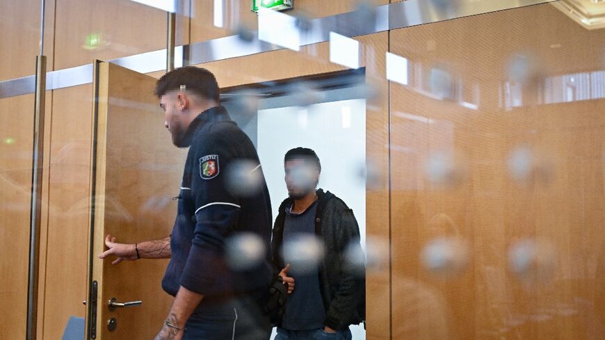 Syrian defendant Issa Al Hasan arrives in court before receiving a life sentence for a knife attack that killed three people in August 2024 