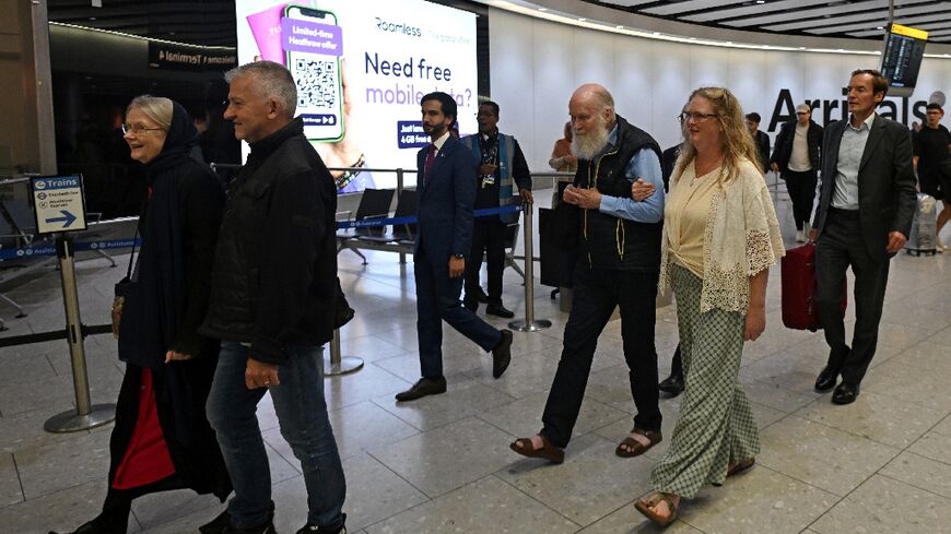 Peter Reynolds, 80, and his wife Barbie, 76, walk through arrivals at London's Heathrow airport accompanied by their daughter Sarah Entwhistle as they arrived back in the UK following their release by the Taliban