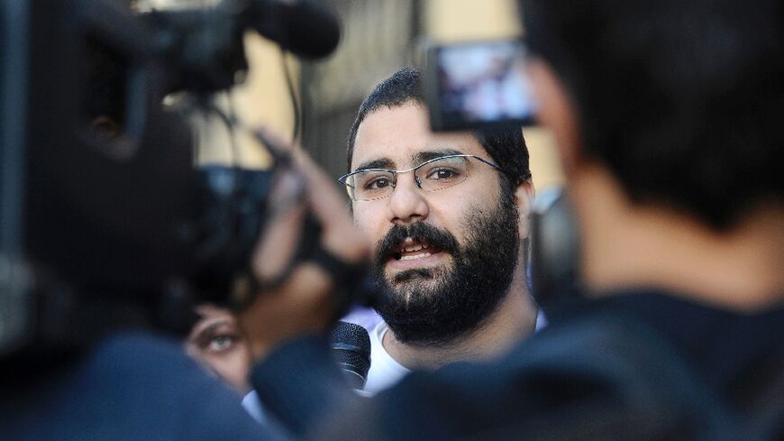(FILES) Egyptian blogger and activist Alaa Abdel Fattah speaks to the press following his release from the police headquarters in Cairo in December 2011