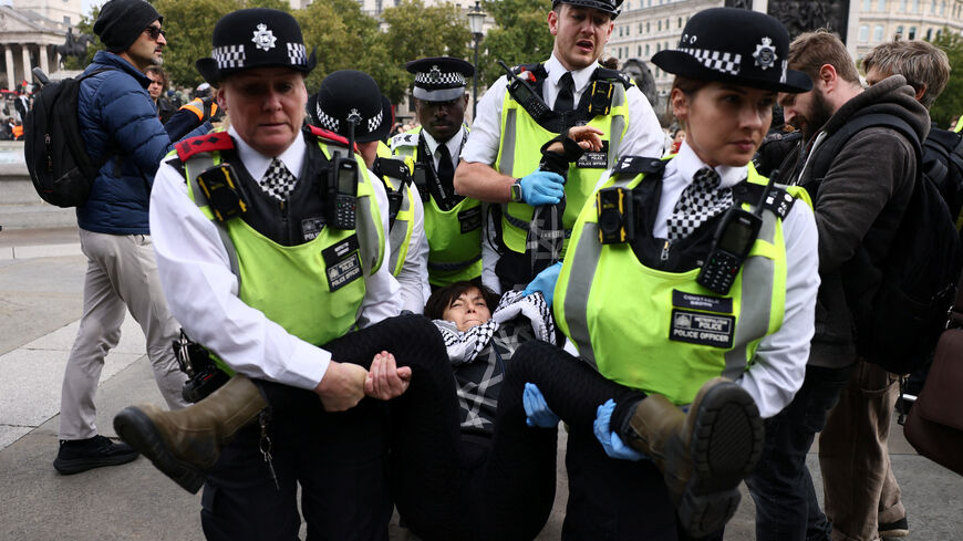 Police officers detain a protester during a mass demonstration organised by Defend our Juries, against the British government's ban on Palestine Action in London, Britain, October 4, 2025. REUTERS/Jack Taylor