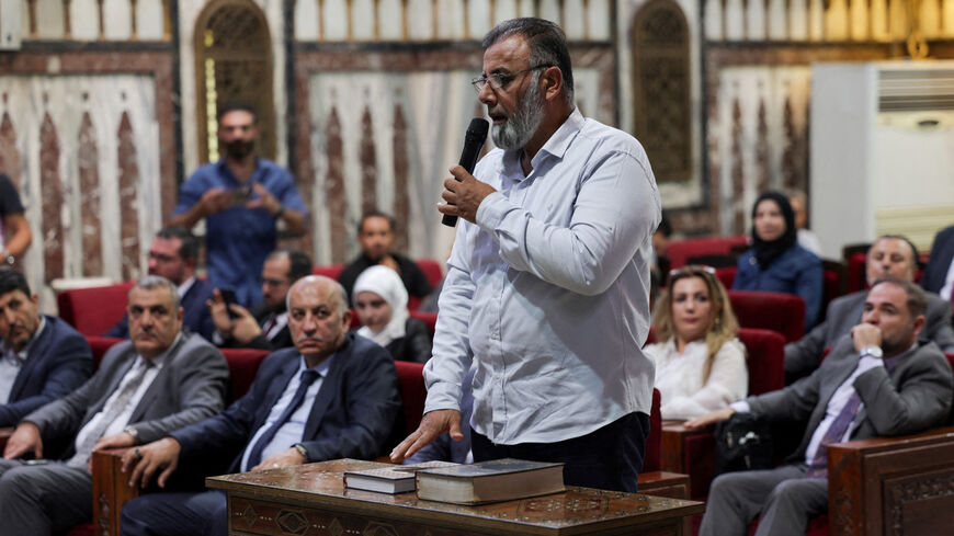 FILE PHOTO: A man takes an oath during the selection of subcommittee members supervising Syrian parliament elections, in Damascus, Syria September 3, 2025. REUTERS/Khalil Ashawi/File Photo