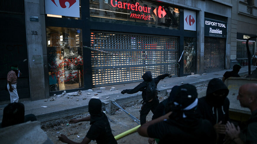 A demonstrator throws an object at a Carrefour shop, as people attend a pro-Palestinian protest condemning Israeli forces' interception of the Global Sumud Flotilla vessels which were aiming to reach Gaza and break Israel's naval blockade, in Barcelona, Spain, October 4, 2025. REUTERS/Lorena Sopena