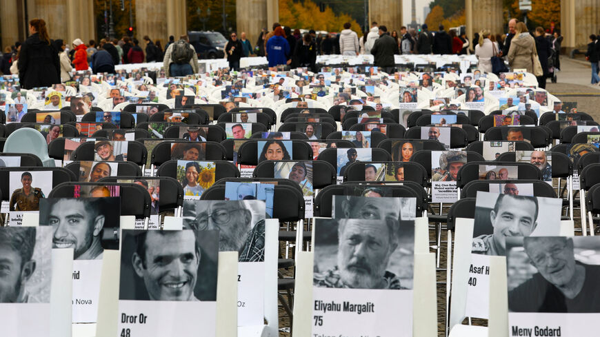 Pictures of victims are placed on chairs as people attend a vigil to mark the two-year anniversary of the deadly October 7, 2023 attack on Israel by Hamas from Gaza, at the Brandenburg Gate in Berlin, Germany, October 7, 2025. REUTERS/Lisi Niesner