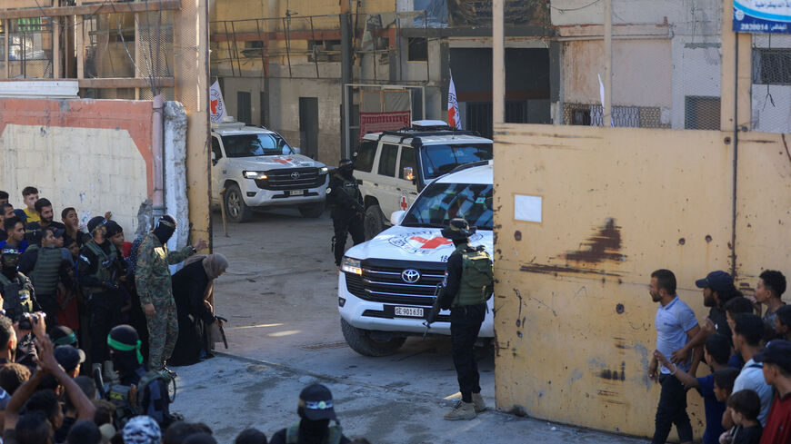 Hamas militants keep guard as Red Cross vehicles transport hostages, held in Gaza since the deadly October 7, 2023 attack, following their handover as part of a ceasefire and hostages-prisoners swap deal between Hamas and Israel, in Gaza City October 13, 2025. REUTERS/Dawoud Abu Alkas
