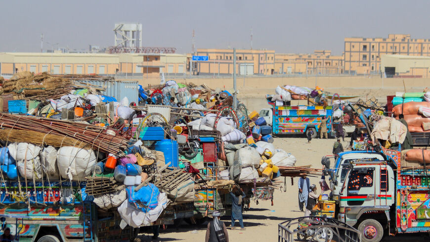 People walk past parked vehicles with belongings of Afghan citizens, as they head back to their country, after Pakistan closed border crossings with Afghanistan, following exchanges of fire between the forces of the two countries in Chaman, the Border Crossing along the Pakistan-Afghanistan Border in Balochistan Province, in Chaman, Pakistan October 12, 2025. REUTERS/Saeed Ali Achakzai
