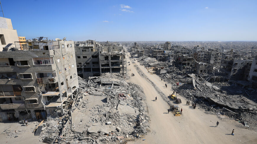 Palestinians walk past the rubble of destroyed buildings, amid a ceasefire between Israel and Hamas, in Gaza City, October 16, 2025. REUTERS/Dawoud Abu Alkas