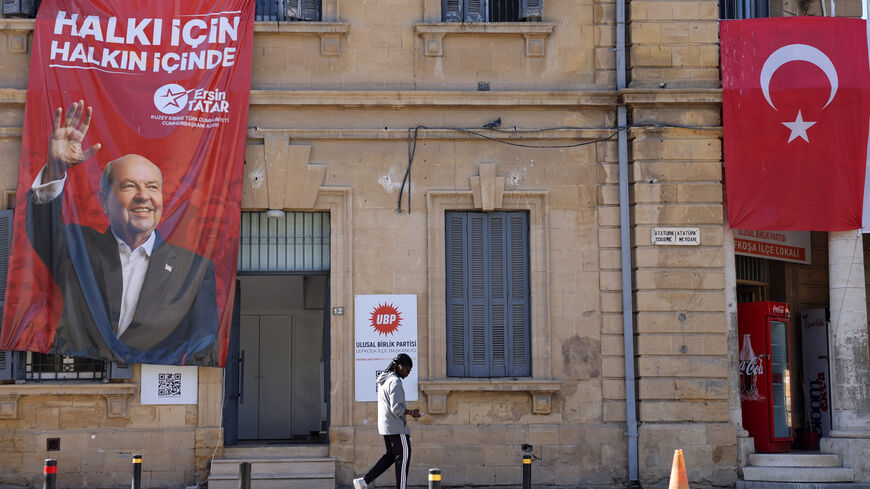 A person walks past a campaign poster of Turkish Cypriot leader and candidate Ersin Tatar ahead of the Turkish Cypriot presidential election in the Turkish-controlled northern Cyprus, in the divided city of Nicosia, Cyprus, October 18, 2025. REUTERS/Yiannis Kourtoglou